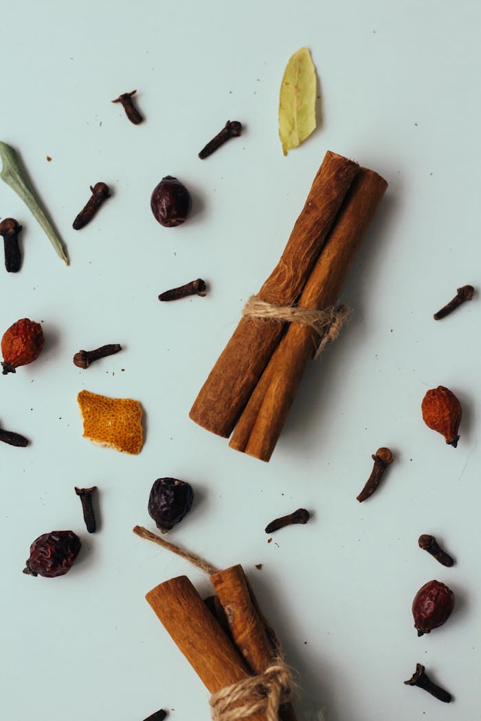 Services Flat lay of cinnamon sticks with assorted spices on a light background.